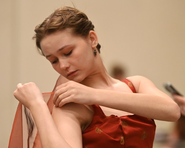 Backstage, putting finishing touches on a gown is model Holly Anderson of Glenview at the 2024 Fashion Show hosted by Friends of Youth Services on June 20, 2024 at the McGrath Family Performing Arts Center at Loyola Academy (1100 Laramie Ave.) in Wilmette. (Karie Angell Luc/Pioneer Press)