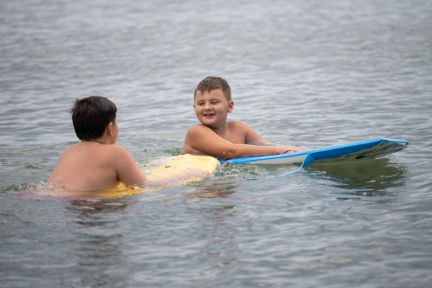 Novak Djuric, 7, on right, and his brother Luka, 10, both of Munster, float off the shores of Porter Beach on Wednesday, June 26, 2024. (Kyle Telechan/for the Post-Tribune)
