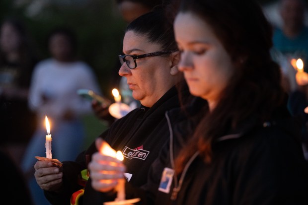 Visitors stand, illuminated by candles, as well-wishes and prayers are said during a candlelight vigil for Dakota Levi Stevens, 10, in Liberty Township on Tuesday, May 7, 2024. (Kyle Telechan/for the Post-Tribune)