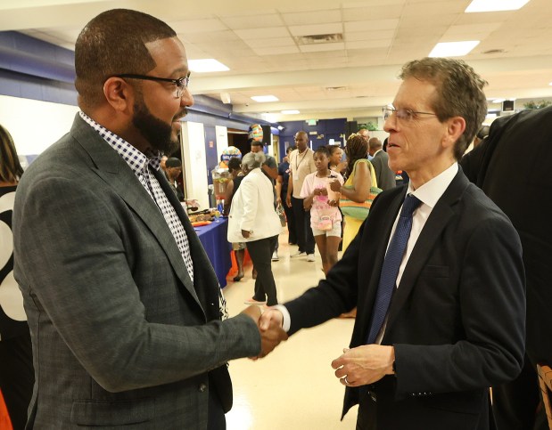 Gary Mayor Eddie Melton (left) shakes hands with MGT Executive Vice President Eric Parish (right) after a meeting in Gary of the Indiana State Distressed Unit Appeal Board to consider terminating the district's distressed status after 7 years of state control on Monday, June 17, 2024. (John Smierciak/Post Tribune)