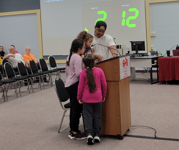 Kenwood Elementary first grader De'Janae Steel, flanked by her dad and two friends, tells the School City of Hammond Board of Trustees what she thinks of its cost-cutting measures. The board voted 3-2 to close three schools, including Kenwood, and shed 173 employees at its April 23 meeting. (Michelle L. Quinn/Post-Tribune)