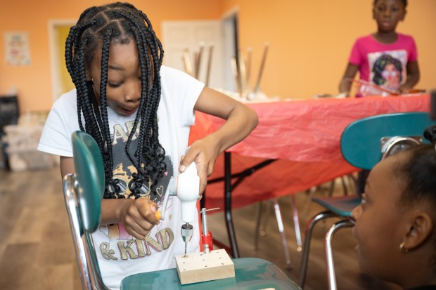 Student Sileir Carpenter, 9, reacts as she drills holes into a board during a Northwest Summer Learning Lab event in partnership with the Urban League of NWI at HOME Mentoring and Tutoring in Gary on Monday, June 24, 2024. (Kyle Telechan/for the Post-Tribune)