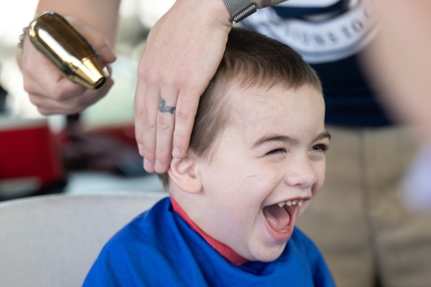 Parker Howes, 3, of Valparaiso, laughs as he has his hair cut by Denmark College barber student Joe Gajewski during the Porter County Health Department's first annual Health and Wellness family Fair on Friday, June 14, 2024. (Kyle Telechan/for the Post-Tribune)