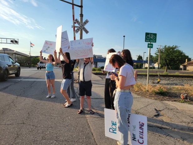 A group of teens from Crown Point hold up signs for passersby during a Dobbs protest in front of the First Unitarian Church of Hobart on June 24, 2024. Monday marked the two-year anniversary of the U.S. Supreme Court decision that overturned Roe v. Wade. (Michelle L. Quinn/Post-Tribune)