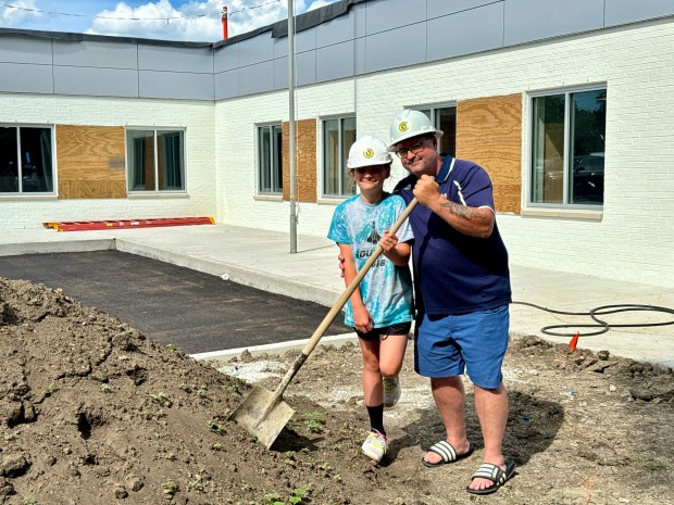 Dave Motsinger and his daughter, Alexis Motsinger, pose with a shovel outside the South Haven Boys & Girls Club on Tuesday, June 18, 2024, as a $5.5 million renovation project wraps up. He was a child when the club was built in 1982. (Doug Ross/for Post-Tribune)