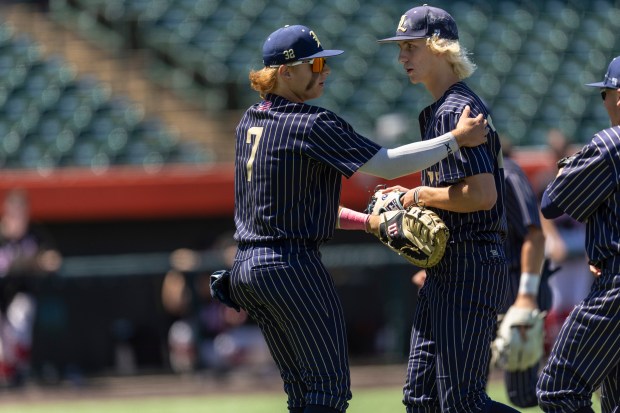 Lemont's Nick Bread (7) congratulates pitcher Shea Glotzbach after an inning against Highland in the Class 3A state semifinals at Duly Health and Care Field in Joliet on Friday, June 7, 2024. (Vincent D. Johnson/for the Daily Southtown)