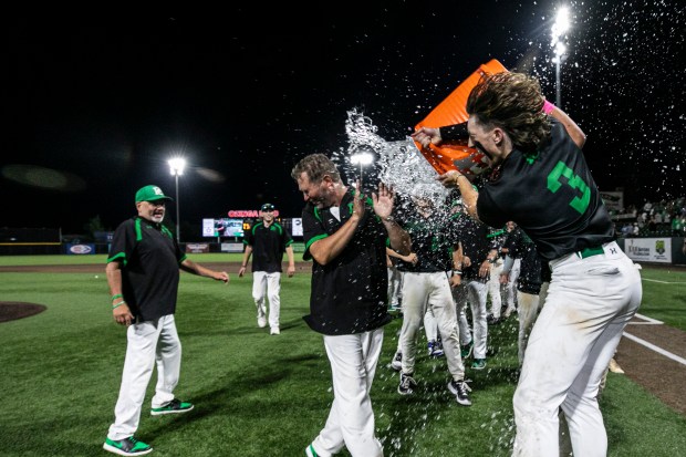 Providence's Cooper Eggert (3) dumps a bucket of water on head coach Mark Smith after the Celtic punch their ticket to the state finals, beating Mount Carmel in the Class 4A Crestwood Supersectional at Ozinga Field in Crestwood on Monday, June 3, 2024. (Vincent D. Johnson/for the Daily Southtown)