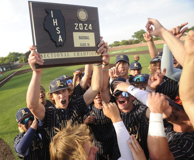 Lemont's Shea Glotzbach (23) holds up the Sectional Campionship plaque after defeating St. Rita during the Class 3A Evergreen Park Sectional final Friday, May 31, 2024 in Evergreen Park, IL. (Steve Johnston/Daily Southtown)