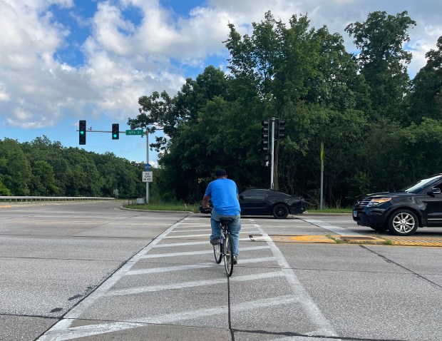 A cyclist crosses an intersection on 167th Street June 23. Since 2010, IDOT's complete streets policy mandates 8- to 10-foot wide shared use paths and pedestrian countdown signals at traffic lights. (Samantha Moilanen/Daily Southtown)