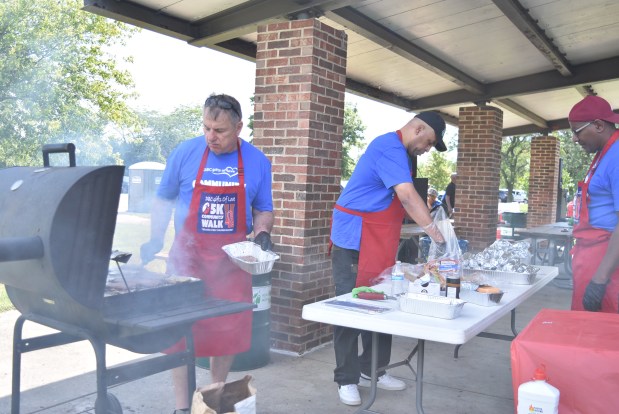 Bryan Oughouse, from left, Sam Woods and Tony Harden, members of the Eastside Church, volunteer their grilling services June 15, 2024, at a 5K fundraiser in Flossmoor for homeless kids. (Jesse Wright/for the Daily Southtown)