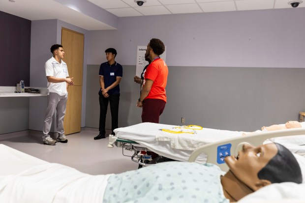 Zenin Miller, left, and Joseph Hernandez, talk with Dr. Jeremy Daigle June 19, 2024, after a simulation at Advocate Christ Medical Center in Oak Lawn. (Vincent D. Johnson/for the Daily Southtown)