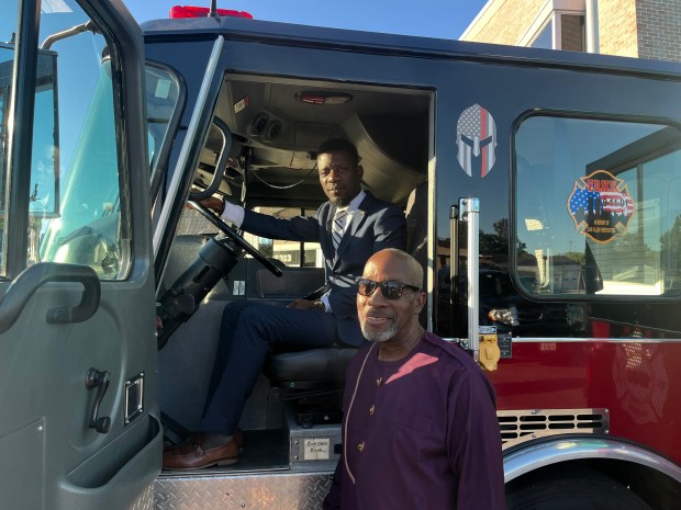 Liberia officials Erasmus T. Williams, seated, and Yeriel Ben-Yehuda check out a fire truck donated to their country by Markham. (Jeff Vorva/for the Daily Southtown)