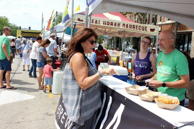 Randi Zitron, left, of Buffalo Grove, visits the Ravinia Brewing Company booth during the Taste of Highland Park in 2019. (Gina Grillo/Pioneer Press)