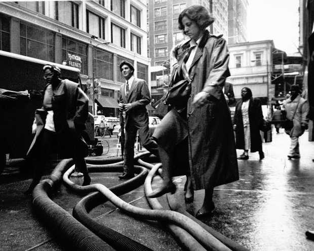 Pedestrians step over hoses used to pump out flood water from buildings at the intersection of State and Madison Streets. Scenes like this on downtown Chicago streets were commonplace in April 1992, due to massive basement and sub-basement flooding caused when crews punctured a century-old freight tunnel located underneath the Chicago River. (Chris Walker/Chicago Tribune)
