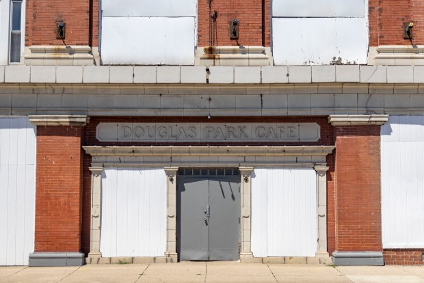 A sign for a former cafe is on the Douglas Park Auditorium building at the corner of Ogden Avenue and Kedzie Boulevard in North Lawndale, June 11, 2024. (Brian Cassella/Chicago Tribune)