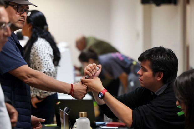 An election official marks the thumbs of a voter with ink after they voted in the Mexican presidential election at the Consulate General of Mexico in Chicago on June 2, 2024. (Eileen T. Meslar/Chicago Tribune)