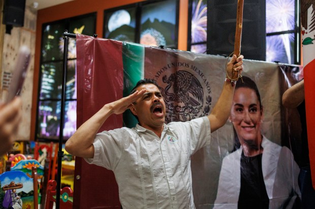 Jesus Guerrero salutes during a Mexico presidential election watch party at Mi Tierra En La Villita, June 2, 2024, in Chicago. Mexico's projected winner Claudia Sheinbaum will become the first female president in the country's 200-year history. (Armando L. Sanchez/Chicago Tribune)