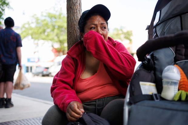 Jessica Juma, from Ecuador, cries while sitting on the street where her husband, Angel Mashiant, went missing on May 25 near a Mariano's in Chicago's Lakeview neighborhood on June 3, 2024. (Armando L. Sanchez/Chicago Tribune)