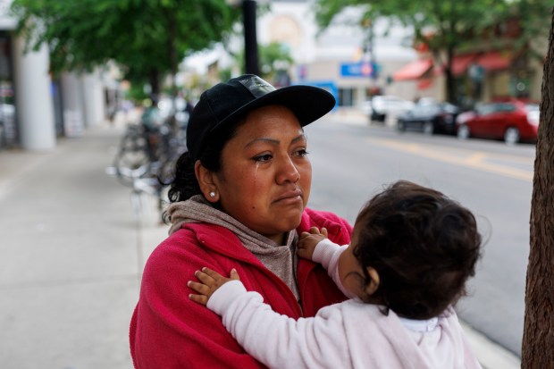 Jessica Juma cries while holding her 6-month-old granddaughter, Sofia Paz, outside a Mariano's in Lakeview near where her husband went missing, June 5, 2024. (Armando L. Sanchez/Chicago Tribune)