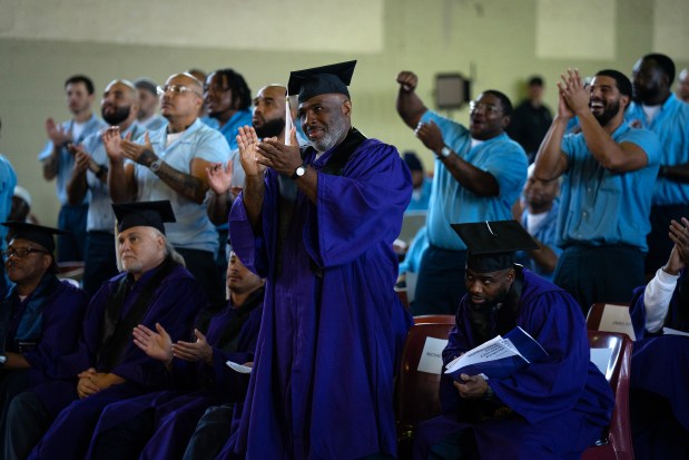 Michael Broadway, center, and his classmates applaud a classmate during commencement ceremonies from the Northwestern Prison Education Program at Stateville Correctional Center on Nov. 15, 2023. (E. Jason Wambsgans/Chicago Tribune)