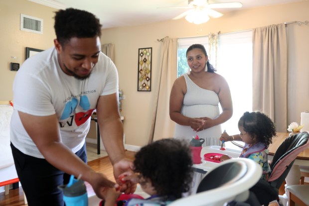 Michael Whitley and Giselle Rodriguez feed their daughters, Nya, 1, left, and Gianna, 2, at their home on June 18, 2024, in Bolingbrook. (John J. Kim/Chicago Tribune)