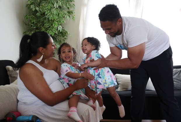 Giselle Rodriguez and Michael Whitley play with their children, Gianna, 2, left, and Nya, 1, at their home on June 18, 2024, in Bolingbrook. (John J. Kim/Chicago Tribune)