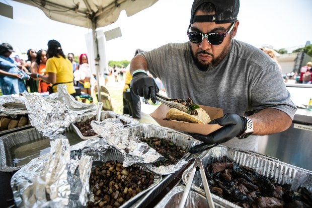 Jesse Flores prepares tacos for El Hongo Mágico Taqueria during Vegandale at Grant Park on June 10, 2023. (Vincent D. Johnson/for the Chicago Tribune)