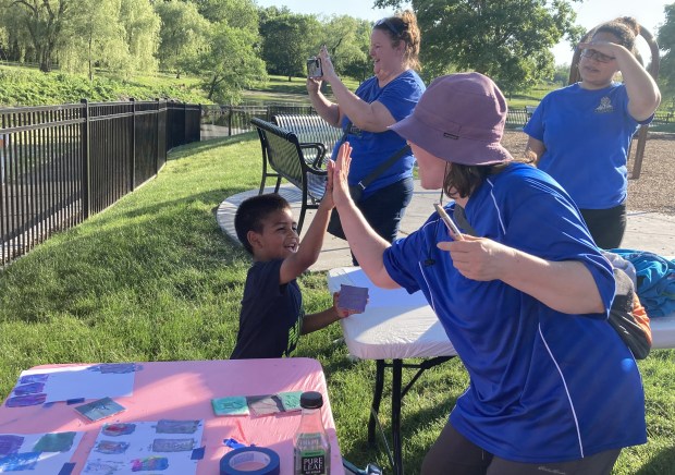 Waukegan Park District's Shannon Smith congratulates Luisangel Motino after he completes part of his art project. (Steve Sadin/For the Lake County News-Sun)