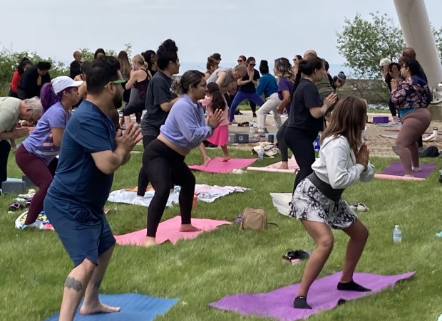 Yoga participants see a difference between putting their mat on the grass or pavement. (Steve Sadin/For the Lake County News-Sun)