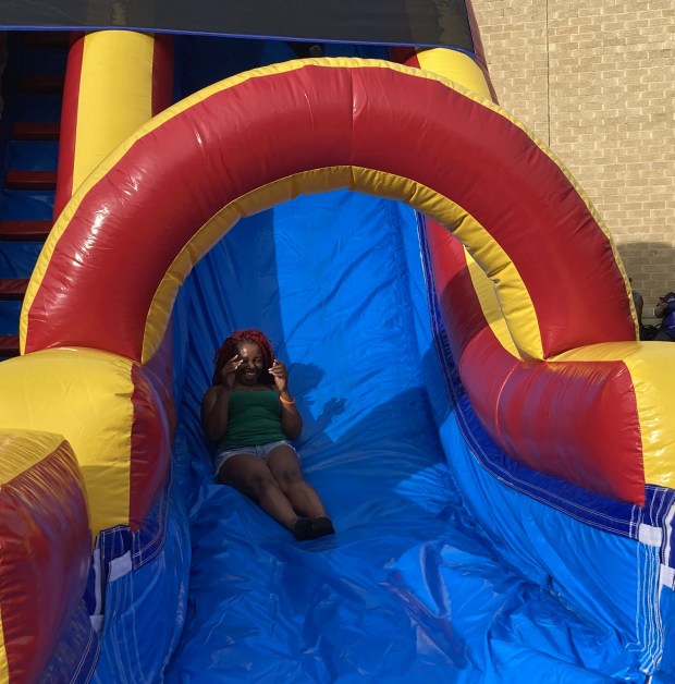 A child slides down a bouncy house slide. (Steve Sadin/For the Lake County News-Sun)