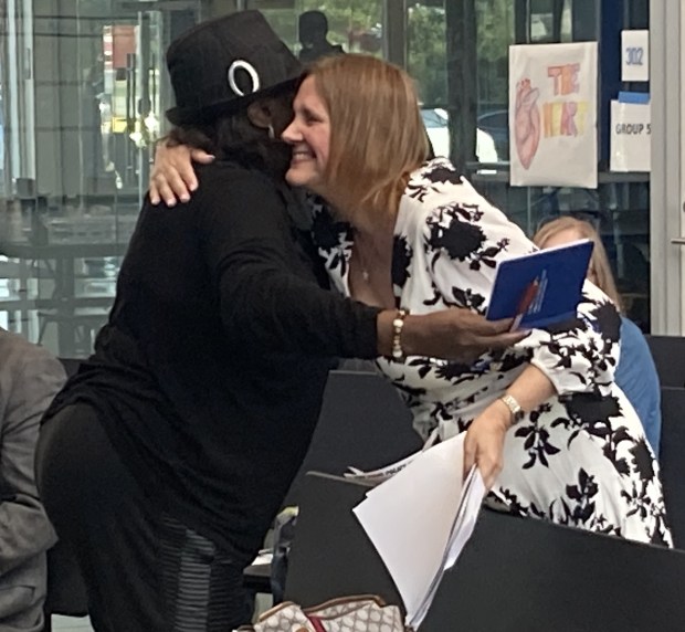 Lake County Board Vice Chair Mary Ross Cunningham, left, and board member Mara Altenberg greet each other at the town hall. (Steve Sadin/For the Lake County News-Sun)