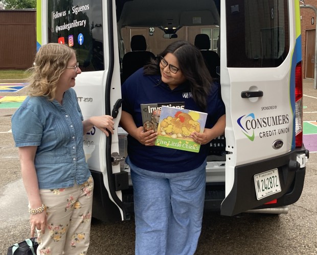 Jennyfer Cordova, right, and Annalisa Teresi begin to unload the Waukegan Public Library's new van for a visit to Washington Elementary School. (Steve Sadin/For the Lake County News-Sun)