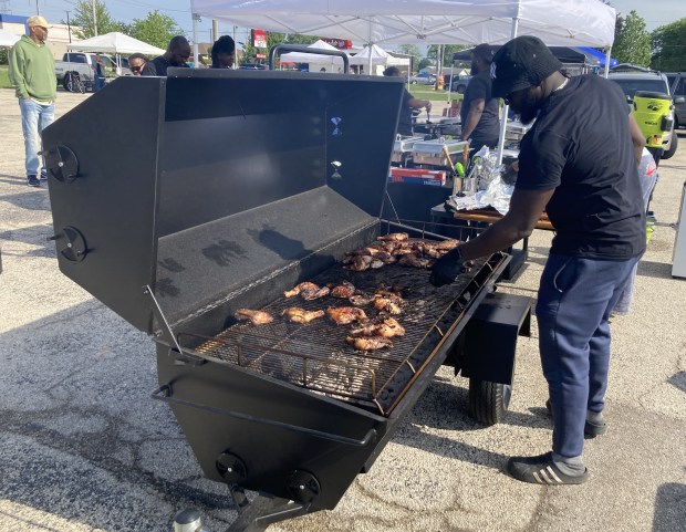 Chad Thaxter grills chicken Friday at the Waukegan Farmers Market opening day. (Steve Sadin/For the Lake County News-Sun)