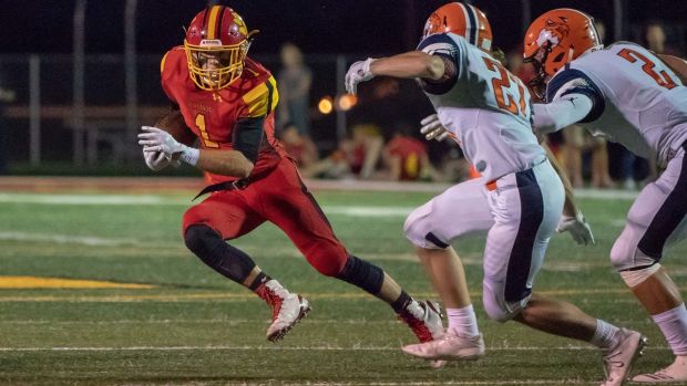 Batavia sophomore Trey Urwiler (1) sweeps to his right and looks for running room beyond two Naperville North defenders on Friday, Aug. 31, 2018.