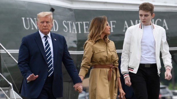 President Donald Trump, first lady Melania Trump and their son, Barron Trump, walk off of Marine One and head toward Air Force One at Morristown Municipal Airport in Morristown, N.J., on Aug. 16, 2020.