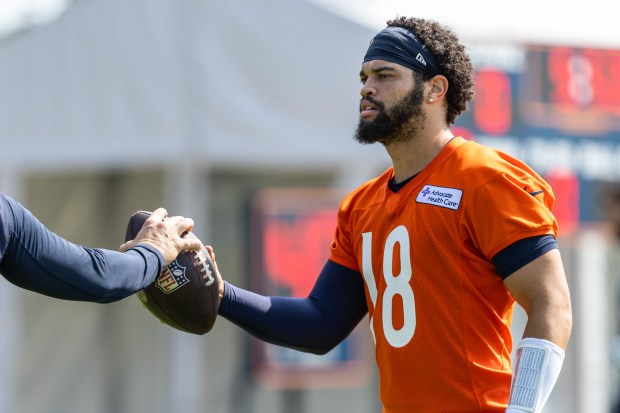 Bears quarterback Caleb Williams is handed the ball during training camp at Halas Hall on July 20, 2024. (Tess Crowley/Chicago Tribune)