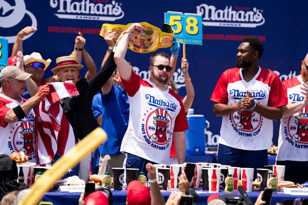 Patrick Bertoletti celebrates winning the men's contest at Nathan's Famous Hot Dog Eating Contest in Coney Island in New York on July 4, 2024. He won by eating 58 hot dogs in 10 minutes. (Graham Dickie/The New York Times)