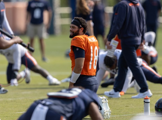 Chicago Bears quarterback Caleb Williams (18) smiles during warm-ups while being filmed by the HBO Hard Knocks crew, left, at Chicago Bears training camp on July 26, 2024, in Lake Forest. (Stacey Wescott/Chicago Tribune)