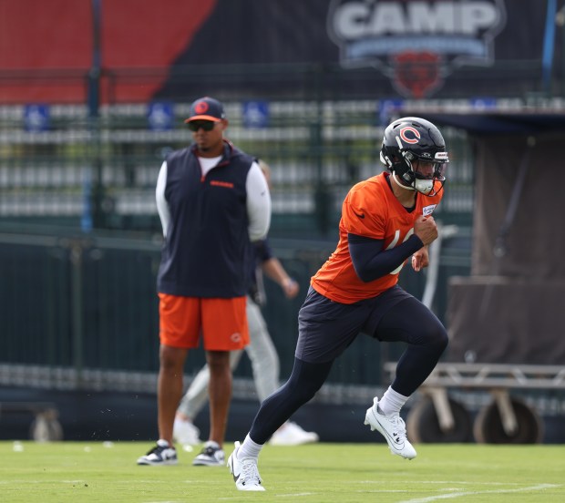 Chicago Bears GM Ryan Poles, left, watches as quarterback Caleb Williams (18) runs runs during training camp at Halas Hall on July 22, 2024, in Lake Forest. (Stacey Wescott/Chicago Tribune)