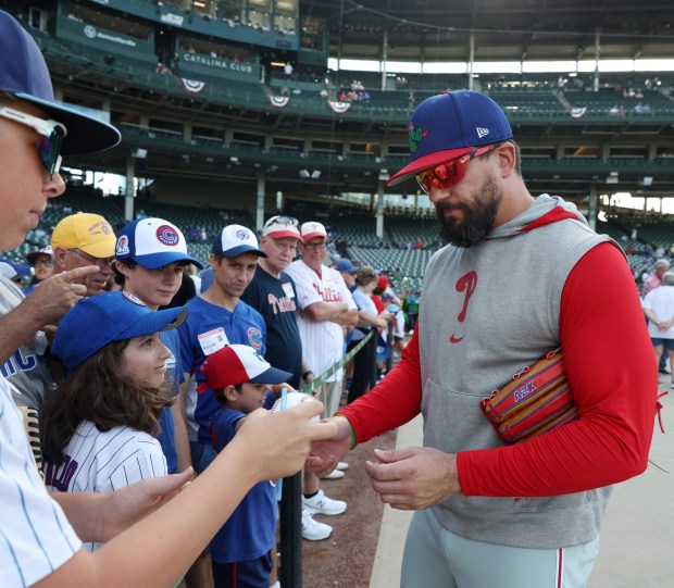 Injured Phillies player Kyle Schwarber signs autographs before a game against the Cubs at Wrigley Field on July 3, 2024, in Chicago. (John J. Kim/Chicago Tribune)