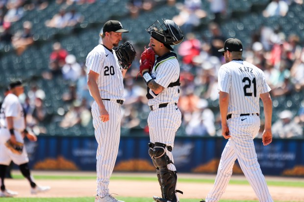 Chicago White Sox pitching coach Ethan Katz (21) walks to the mound where catcher Korey Lee (26) and pitcher Erick Fedde (20) huddle up after Fedde gave up a walk to load the bases during the first inning against the Minnesota Twins at Guaranteed Rate Field on July 10, 2024. (Eileen T. Meslar/Chicago Tribune)