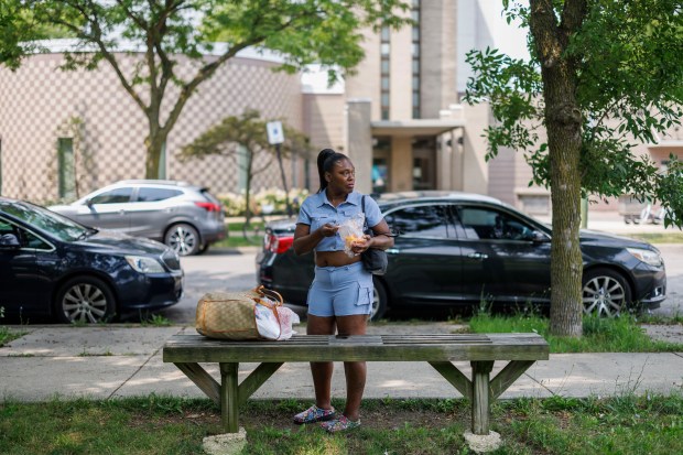 Tonyanika Harris, 53, eats fruit near a Chicago Public Library on West Madison Street near the United Center, July 23, 2024, in Chicago. Workers inside the library said it would remain open during the Democratic National Convention next month. (Armando L. Sanchez/Chicago Tribune)