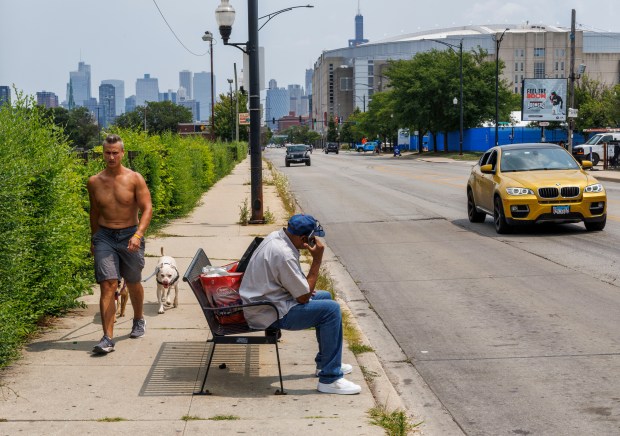 William Tracy, 71, sits at a bus stop after going to the grocery store on West Madison Street near the United Center on July 23, 2024. (Armando L. Sanchez/Chicago Tribune)