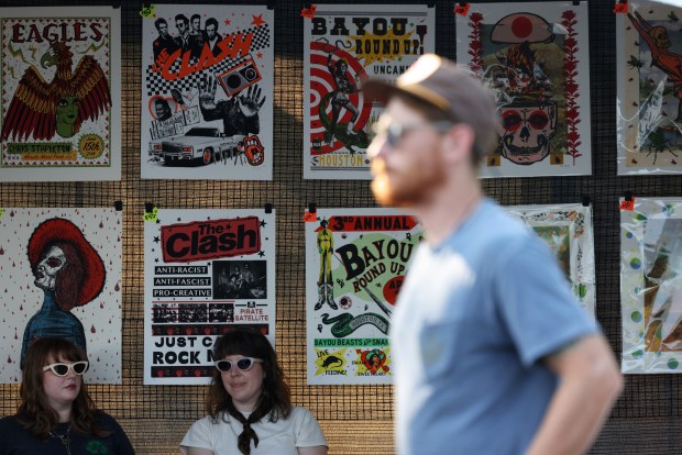 Kathleen So, left, and Tess Doyle work at Doyle's booth in the Flatstock poster fair during Pitchfork Music Festival at Union Park Friday, July 19, 2024, in Chicago. (John J. Kim/Chicago Tribune)