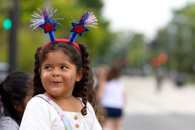Novalee Alvarez, 3, watches the Independence Day parade in Highland Park. (Stacey Wescott/Chicago Tribune)