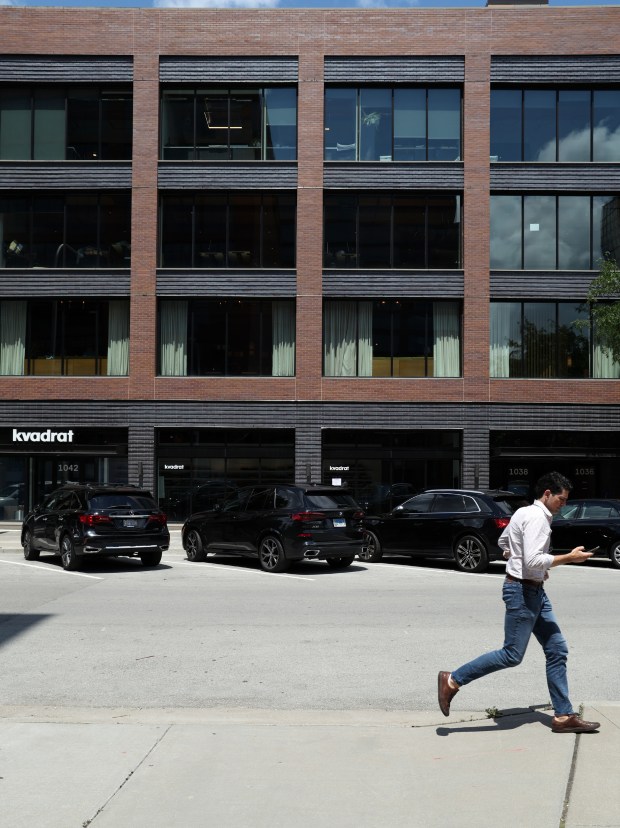 A person runs past the building housing Summit Design + Build in Fulton Market in Chicago on July 18, 2024. It is a mixed-use timber building. (Terrence Antonio James/Chicago Tribune)