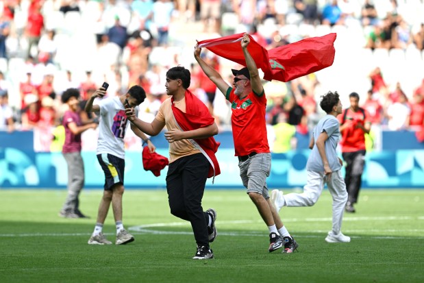 Fans of Morocco invade the pitch during an Olympic men's soccer match against Argentina on July 24, 2024, in Saint-Etienne, France. (Tullio M. Puglia/Getty Images)