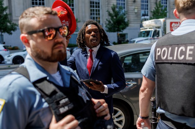 Holding a Make America Great Again hat Vashon Tuncle, 27, of Englewood argues with activists after former President Donald Trump spoke at the National Association of Black Journalists convention at the Hilton Chicago on July 31, 2024. (Armando L. Sanchez/Chicago Tribune)