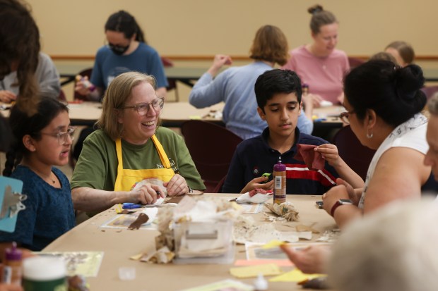 Leslie Shad, second from left, of Bird-Friendly Evanston, helps Zoya Rahman, from left, Ayaan Rahman, and Kulsum Zaidi during a bird-making workshop for Bird Collisions in the Anthropocene at the Evanston Public Library on July 15, 2024. (Eileen T. Meslar/Chicago Tribune)