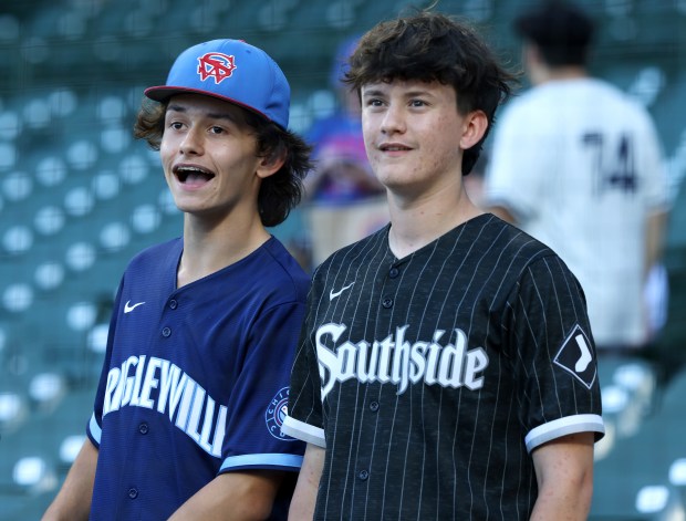 A Cubs fan and a White Sox fan watch batting practice before a game at Wrigley Field on June 5, 2024. (John J. Kim/Chicago Tribune)